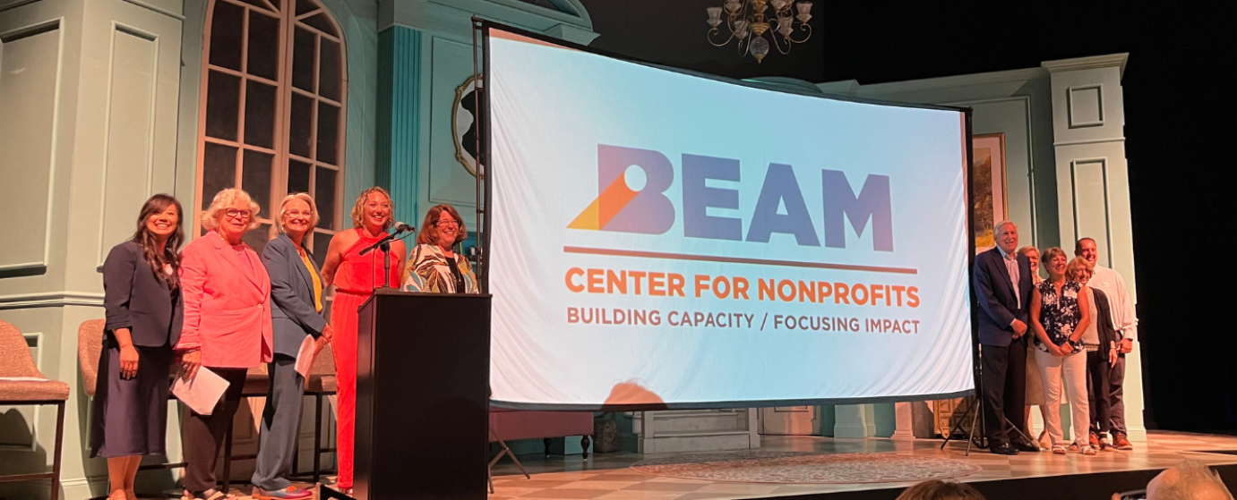 BEAM steering committee on stage with BEAM logo on screen